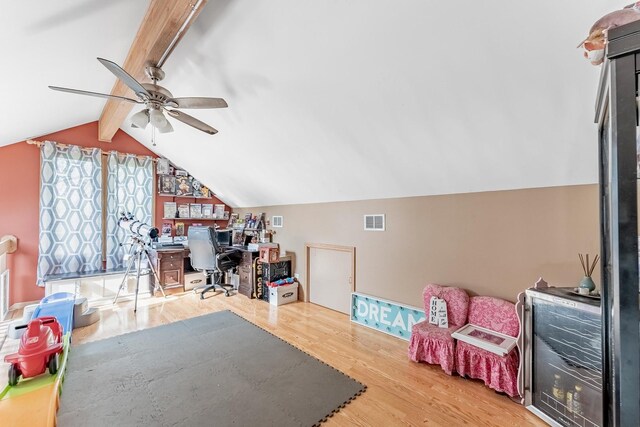 office with a ceiling fan, visible vents, lofted ceiling with beams, and wood finished floors