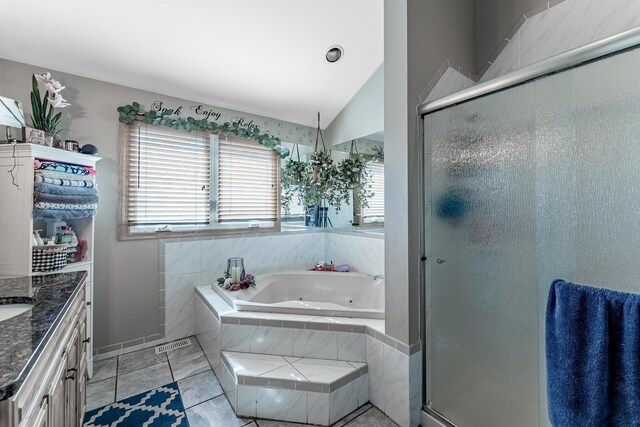 full bathroom featuring a whirlpool tub, a stall shower, vaulted ceiling, and vanity