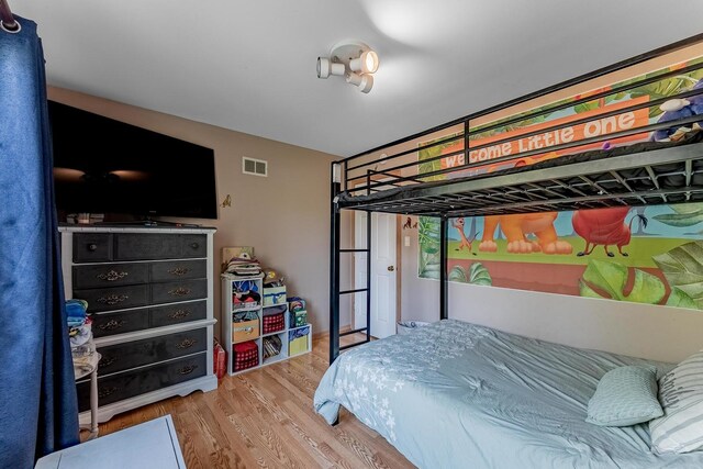 bedroom featuring visible vents and wood finished floors