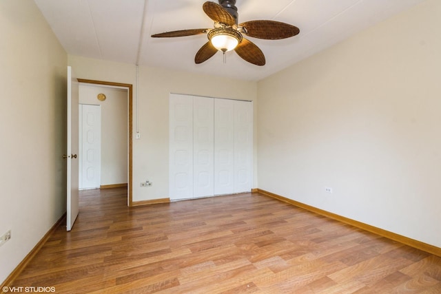 unfurnished bedroom featuring baseboards, light wood finished floors, ceiling fan, and a closet
