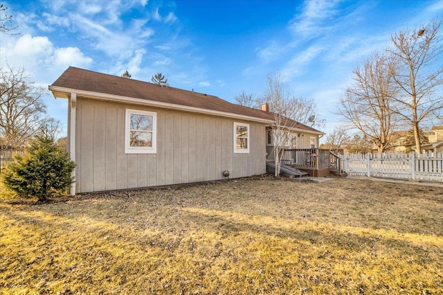back of house with fence, a yard, and a deck