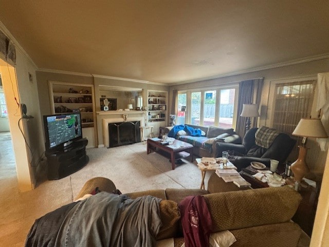 carpeted living area featuring crown molding, built in shelves, and a fireplace