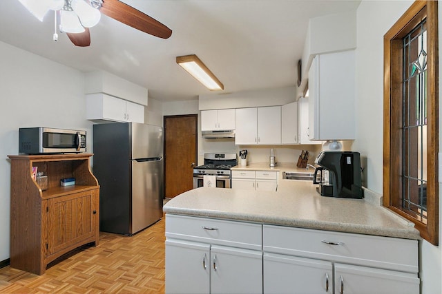 2206 Highland Dr, Sycamore, IL 60178 - kitchen featuring appliances with stainless steel finishes, under cabinet range hood, a peninsula, a ceiling fan, and white cabinetry