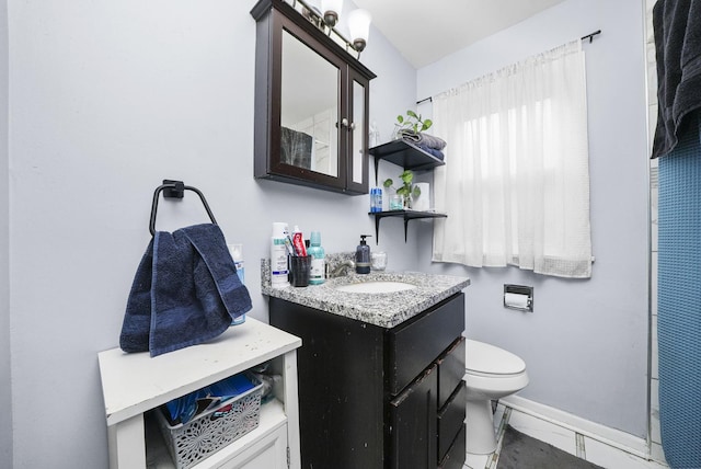 bathroom featuring toilet, baseboards, marble finish floor, and vanity