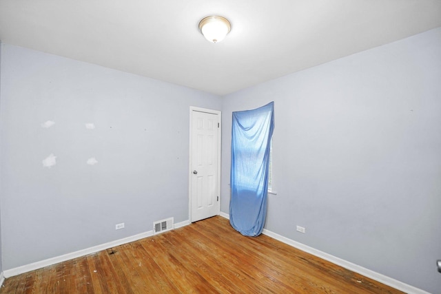 unfurnished room with visible vents, baseboards, and wood finished floors
