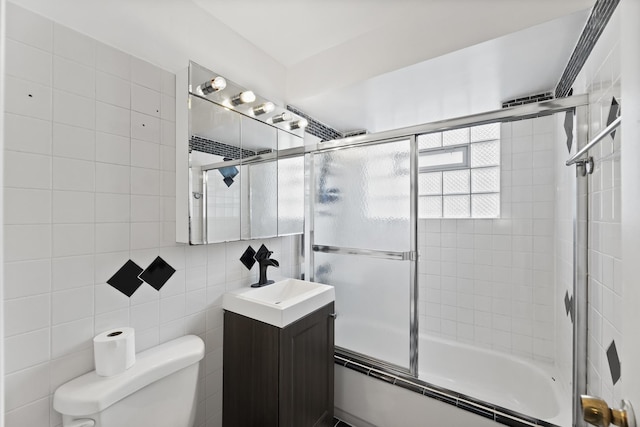 full bath featuring vanity, enclosed tub / shower combo, toilet, and tile walls