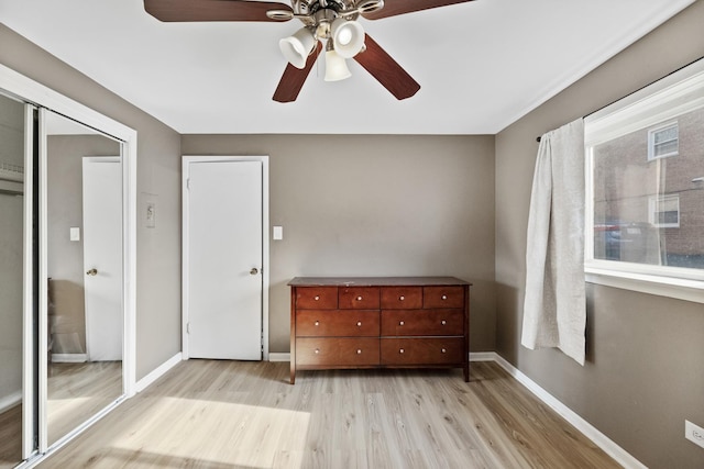bedroom featuring baseboards, a ceiling fan, and light wood finished floors