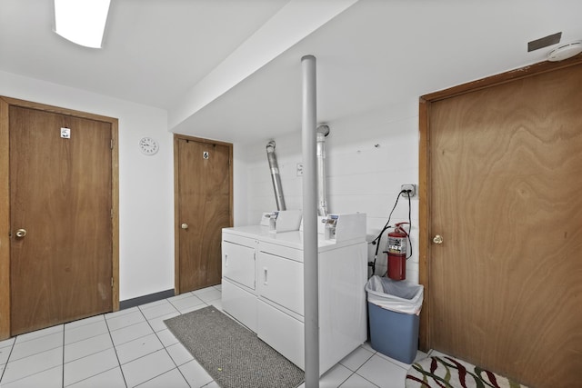 clothes washing area with washer and dryer, laundry area, and light tile patterned floors