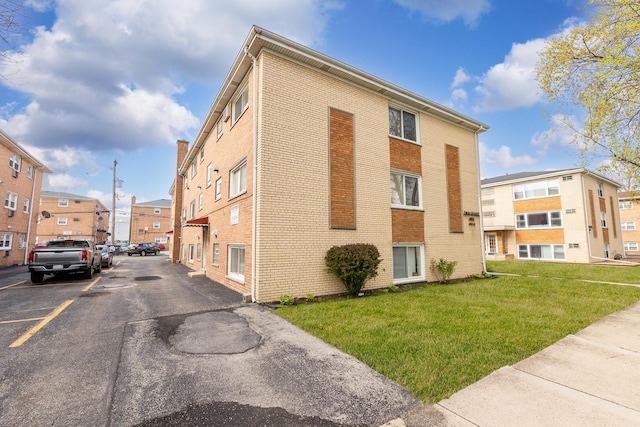 view of building exterior featuring a residential view and uncovered parking