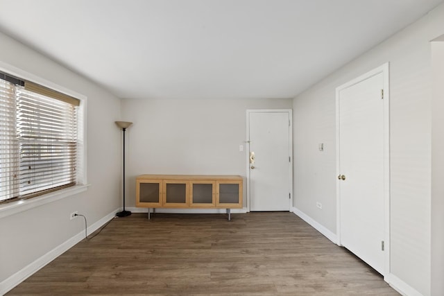 unfurnished room featuring baseboards and wood finished floors