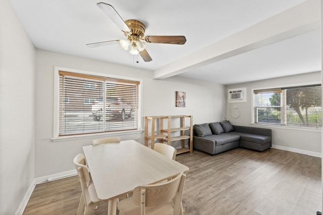 dining room with baseboards, a wall mounted AC, a ceiling fan, and light wood-style flooring