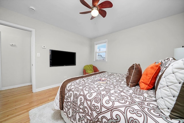 bedroom with baseboards, ceiling fan, and light wood-type flooring