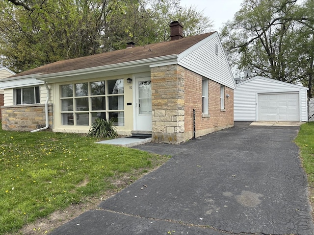 view of front of house featuring a front lawn, stone siding, a garage, an outbuilding, and a chimney