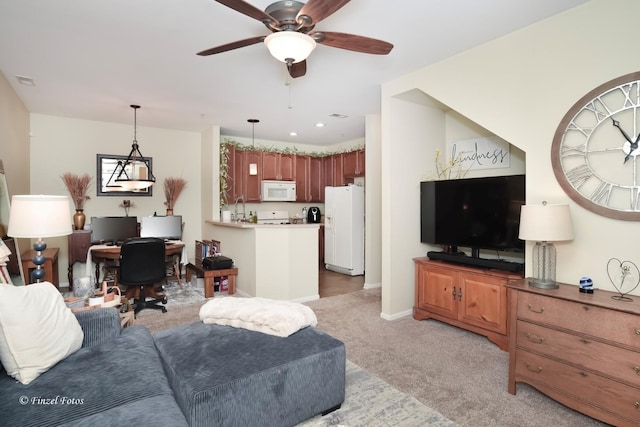 living area featuring light colored carpet, a ceiling fan, baseboards, and visible vents