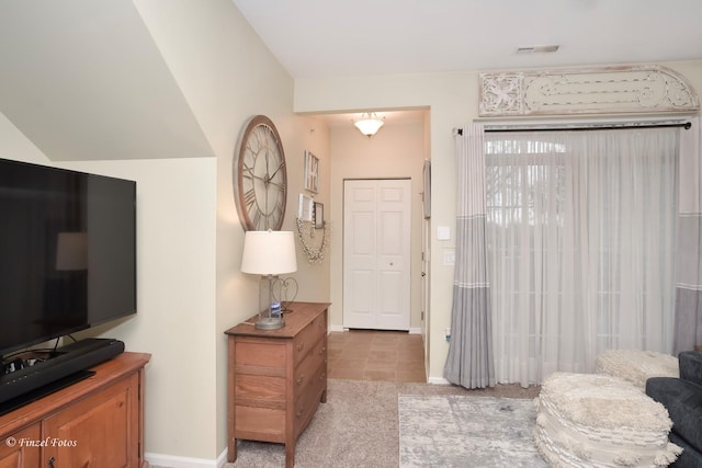 interior space with light tile patterned flooring, baseboards, and light colored carpet