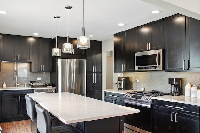kitchen with a breakfast bar area, a center island, a sink, backsplash, and stainless steel appliances