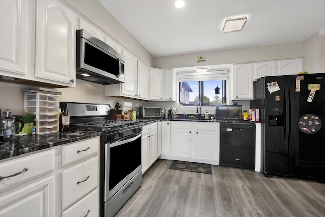 7333 Winthrop Way Unit 10, Downers Grove, IL 60516 - kitchen featuring black appliances, a sink, white cabinets, light wood-type flooring, and dark stone countertops