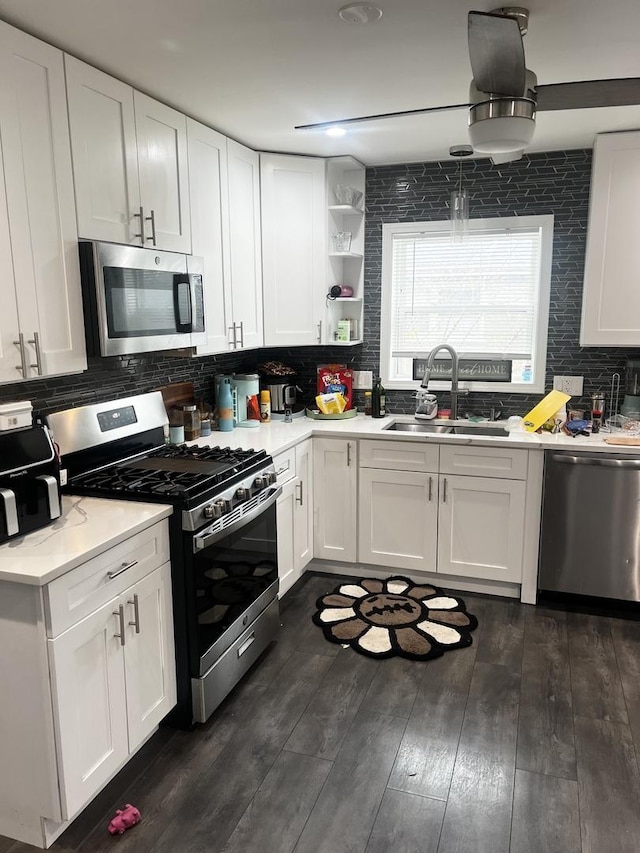 kitchen with a sink, open shelves, white cabinetry, decorative backsplash, and appliances with stainless steel finishes