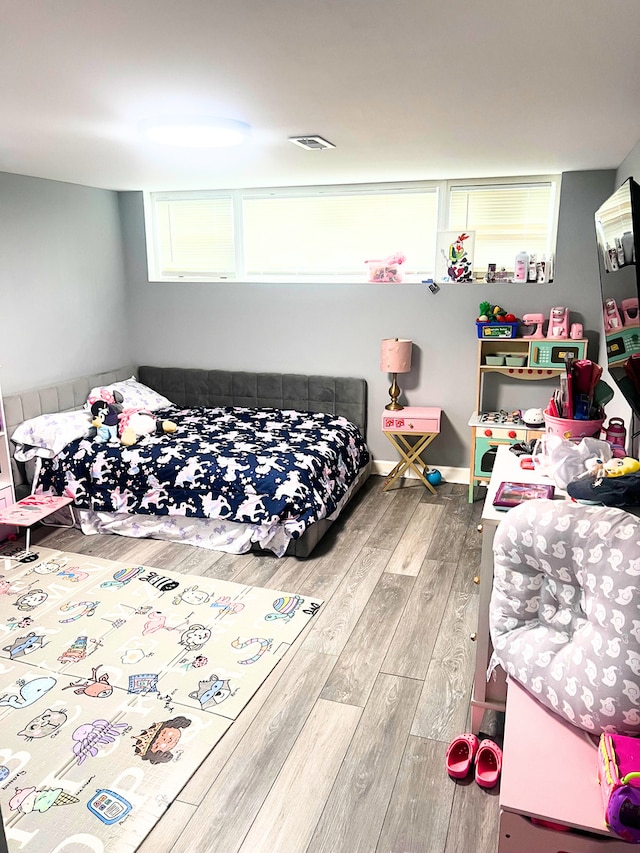 bedroom featuring visible vents and wood finished floors