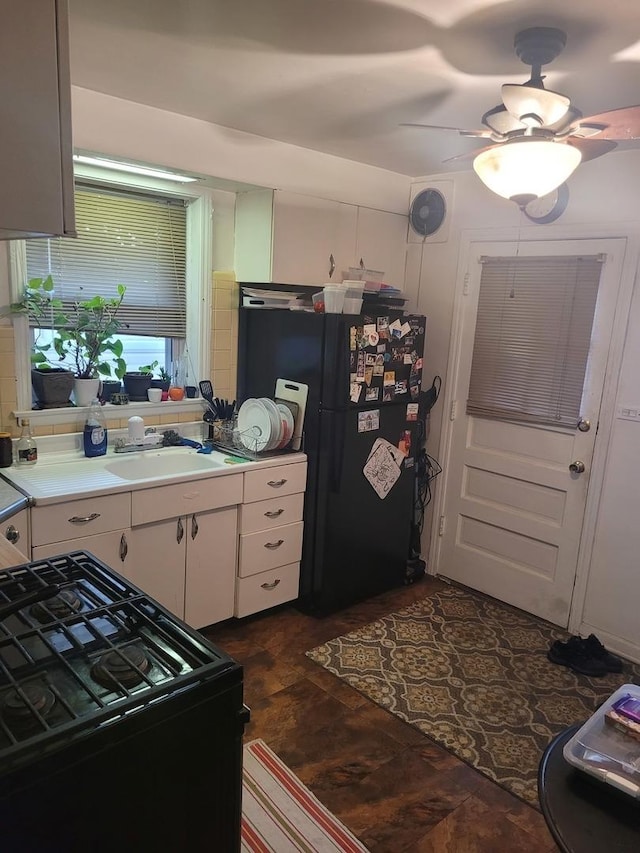 kitchen with ceiling fan, a sink, light countertops, white cabinets, and black appliances