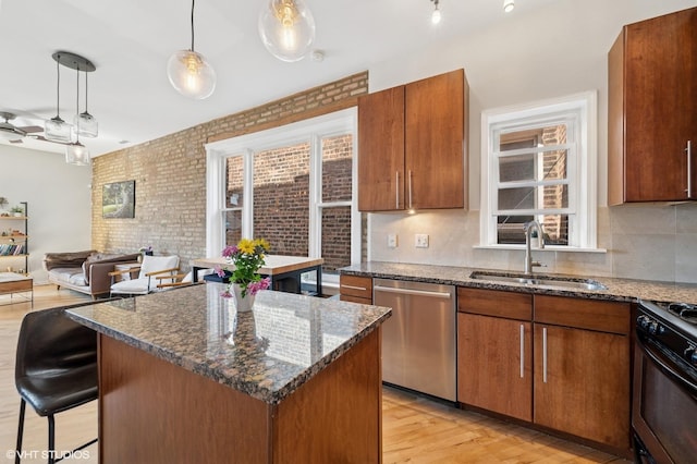 kitchen featuring a healthy amount of sunlight, a sink, black range with gas stovetop, and dishwasher