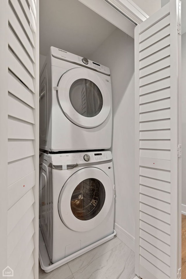 8631 W Grand Ave Unit 4W, River Grove, IL 60171 - clothes washing area featuring baseboards, laundry area, stacked washer / dryer, and marble finish floor