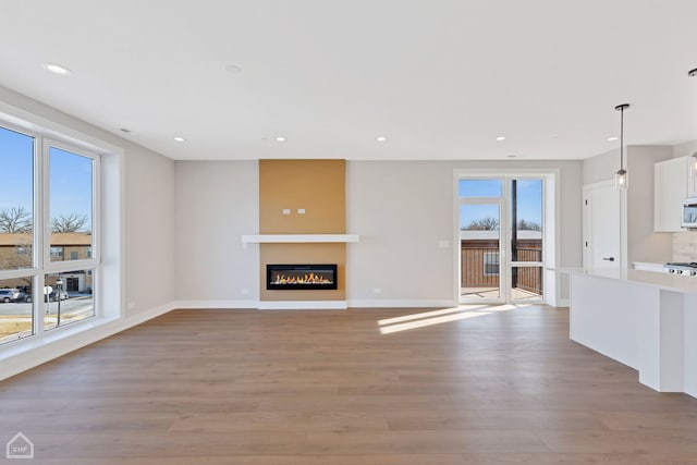 8631 W Grand Ave Unit 4W, River Grove, IL 60171 - unfurnished living room featuring light wood-style floors, recessed lighting, baseboards, and a glass covered fireplace