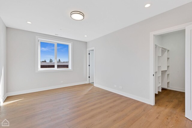 8631 W Grand Ave Unit 4W, River Grove, IL 60171 - unfurnished bedroom featuring recessed lighting, baseboards, a walk in closet, and light wood finished floors