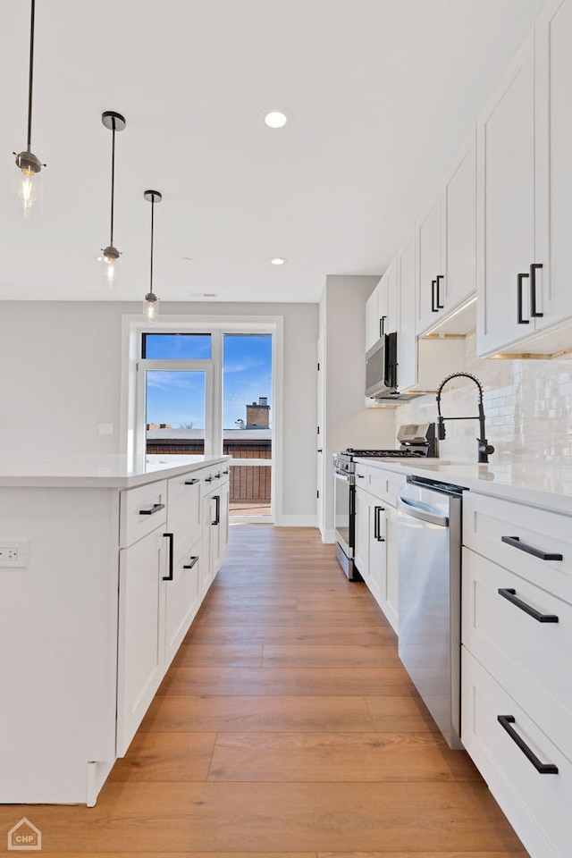 8631 W Grand Ave Unit 4W, River Grove, IL 60171 - kitchen featuring baseboards, light wood-type flooring, light countertops, white cabinetry, and appliances with stainless steel finishes