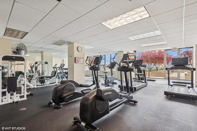 gym featuring floor to ceiling windows and a paneled ceiling