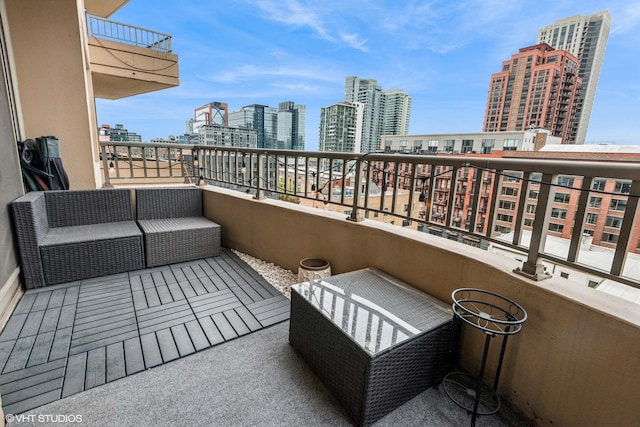 balcony with a view of city and an outdoor hangout area