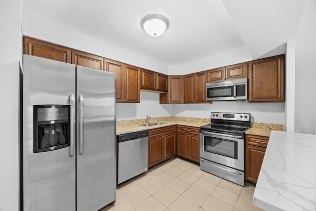 6118 N Sheridan Rd Unit 304, Chicago, IL 60660 - kitchen featuring light tile patterned flooring, light stone countertops, brown cabinets, a sink, and appliances with stainless steel finishes