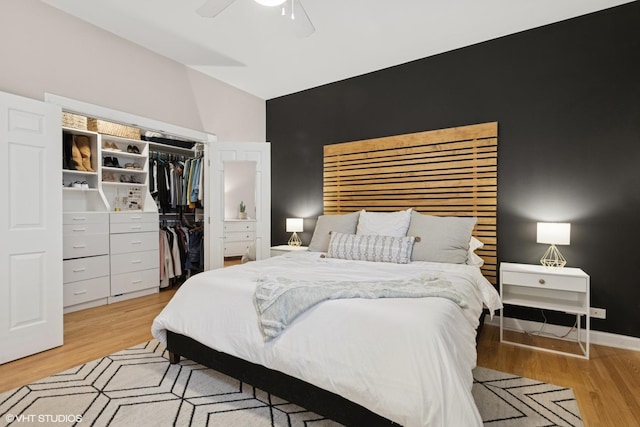 bedroom with a ceiling fan, lofted ceiling, light wood finished floors, and a closet