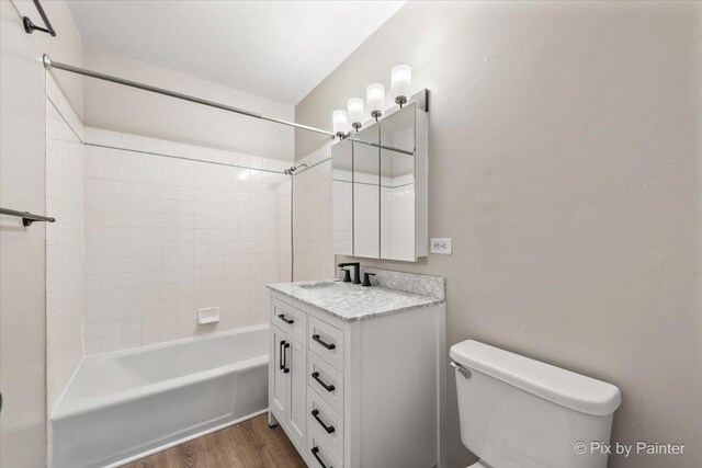 full bathroom with vanity, toilet, wood finished floors, and shower / bathing tub combination