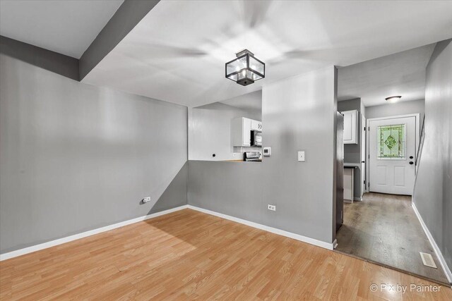interior space featuring baseboards and light wood-style flooring