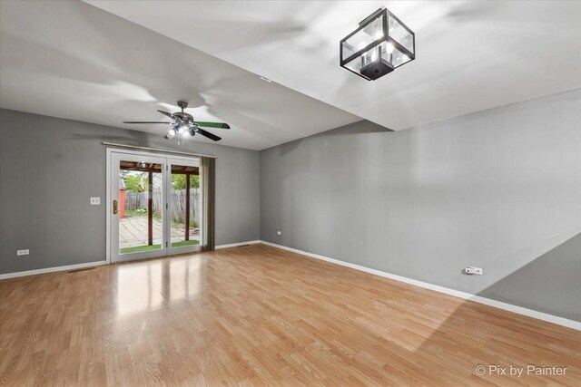 spare room featuring baseboards, ceiling fan, and light wood-type flooring