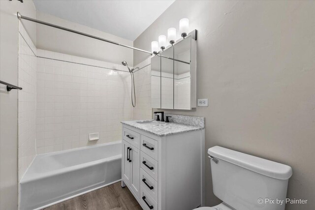 bathroom featuring bathing tub / shower combination, vanity, toilet, and wood finished floors