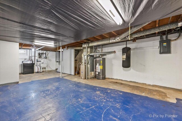 unfinished below grade area featuring washer / dryer, heating unit, water heater, and electric panel