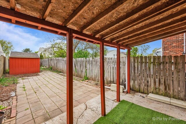 view of patio / terrace with an outbuilding, a shed, and a fenced backyard