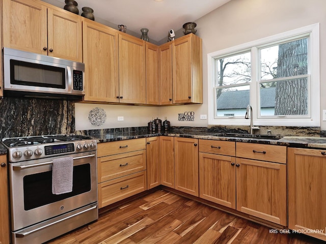 2601 N Villa Ln, Mchenry, IL 60051 - kitchen featuring appliances with stainless steel finishes, a sink, dark wood-type flooring, and dark stone countertops