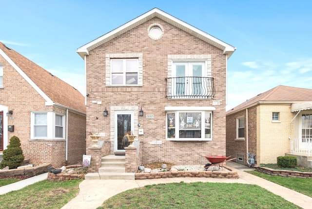 traditional-style home with a balcony and brick siding