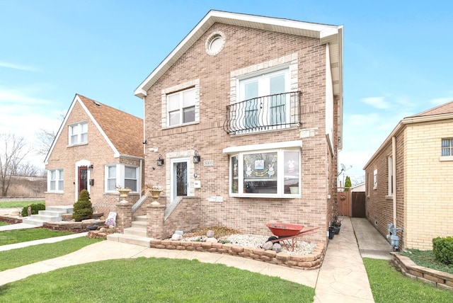 view of front of house featuring brick siding, fence, and a front yard