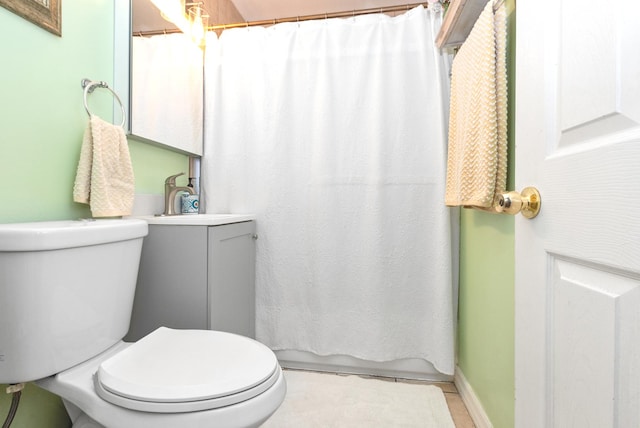 bathroom with toilet, baseboards, and a sink