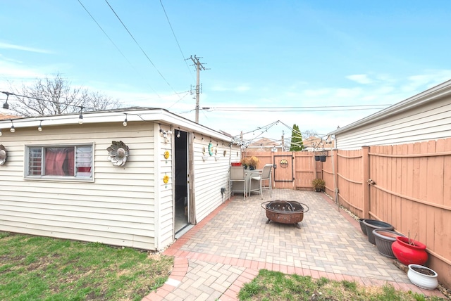exterior space with a fenced backyard, an outbuilding, and a fire pit