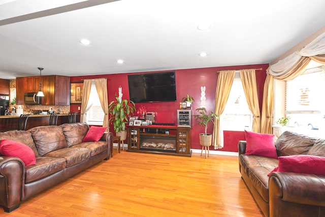 living room featuring recessed lighting, baseboards, and light wood-style floors
