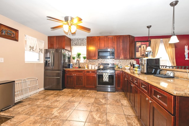 kitchen featuring reddish brown cabinets, decorative backsplash, appliances with stainless steel finishes, and ceiling fan