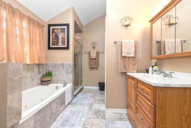 bathroom with a jetted tub, a shower stall, baseboards, vanity, and lofted ceiling