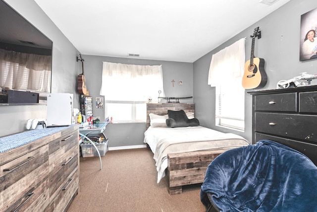 carpeted bedroom with baseboards and visible vents