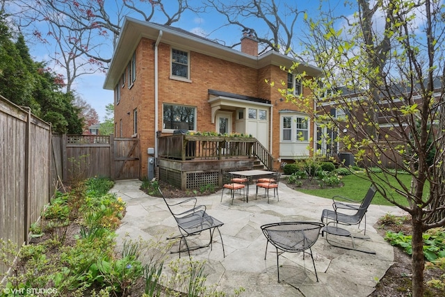 2334 Central Park Ave, Evanston, IL 60201 - back of property featuring a chimney, outdoor dining area, a deck, a patio area, and a fenced backyard