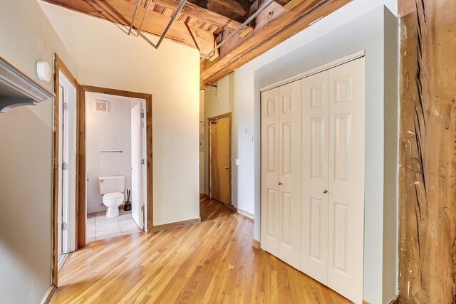 hall featuring baseboards and light wood-style flooring
